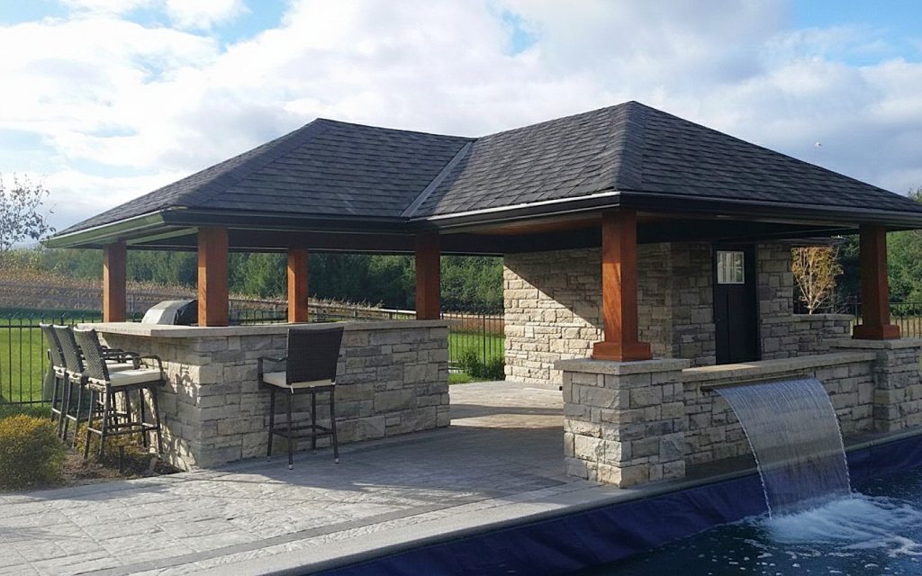Pool cabana with outdoor kitchen and waterfall