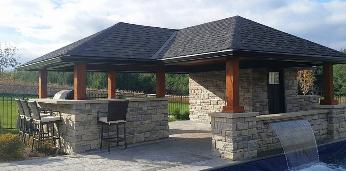 Pool cabana with outdoor kitchen and waterfall