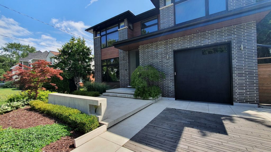 Concrete front yard landscaping with decorative wall with house number